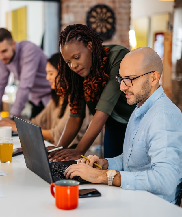 Colleagues Consulting With Each Other While Working Together In The Office